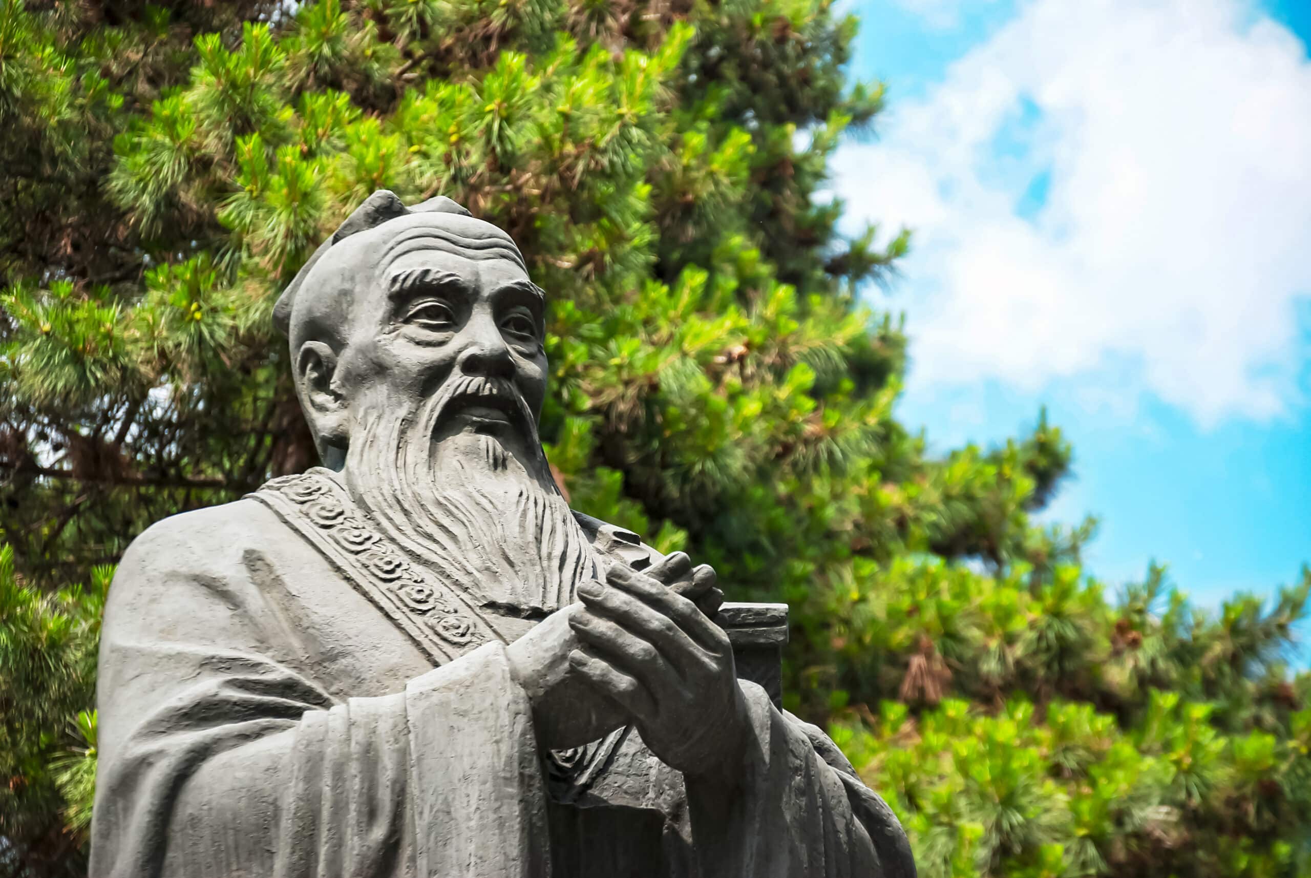 A statue of Confucius with hands folded in thought—representing the enduring relevance of his teachings for everyday life.